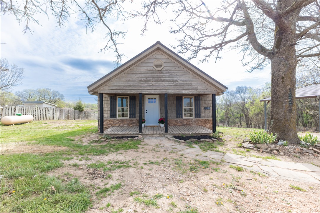 Beautifully remodeled 3 bed, 2 bath home on 1.52 acres just minutes from town! Enjoy the perfect blend of convenience and space with room to expand or create your own hobby farm. This property offers strong investment potential as land values continue to rise, with a paved road coming by 2027. Inside, you’ll find quartz countertops, stainless steel appliances, custom cabinets with soft-close doors and drawers, new HVAC, hot water heater, tile bathrooms, and durable wood laminate flooring. Relax on the back porch and take in stunning sunrises, or unwind in the evenings with breathtaking sunsets. Located in the heart of Northwest Arkansas with no restrictions or covenants—this one is a true gem!
