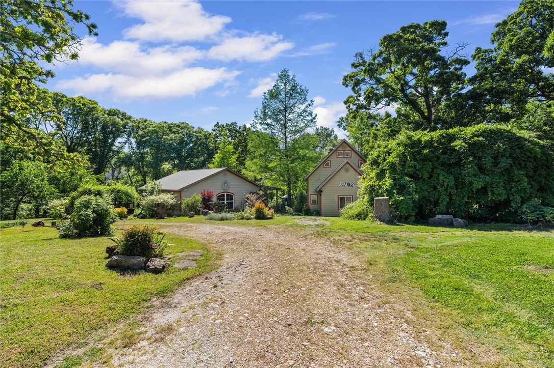 Looking for the perfect setup for a mother-in-law suite or a private home office? 4702 Rocky Ridge Trail provides the space and separation you’ve been searching for. Situated on 3.92 surveyed acres, this property offers a peaceful, park-like setting with two distinct homes.
The main home (1,319 sq/ft) features a cozy 2-bedroom, 2-bath configuration, while the second shop/home (1,024 sq/ft) offers a private 1-bedroom, 1-bath retreat. This setup is ideal for families wanting to stay close while maintaining independence. With nearly 4 acres to play with, there is plenty of room for gardens, workshops, or simply enjoying the quiet of Little Flock. All this, plus easy access to I-49 and the entire NWA corridor!