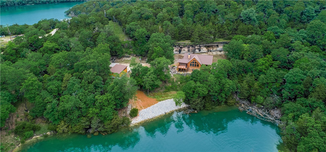 Custom built,  energy efficient hybrid log home with 2" x 6" walls and log siding.   So much attention to detail that there is not enough room to list!  Views of main channel of lake, solar shades, gorgeous bluffs in rear of home with lighting, leatherized granite countertops, tongue and groove tie beamed ceilings, Asian Walnut hardwood floors throughout, in floor heating system in master bath, 4 decks and screened in porch to name a few.    Home has full basement with 9' ceilings with huge workshop.  Some furnishings to convey. 10 x 24 boat slip with lift to convey. Ranger in garage to convey for use to boat slip etc.  Proof of funds needed with offers
