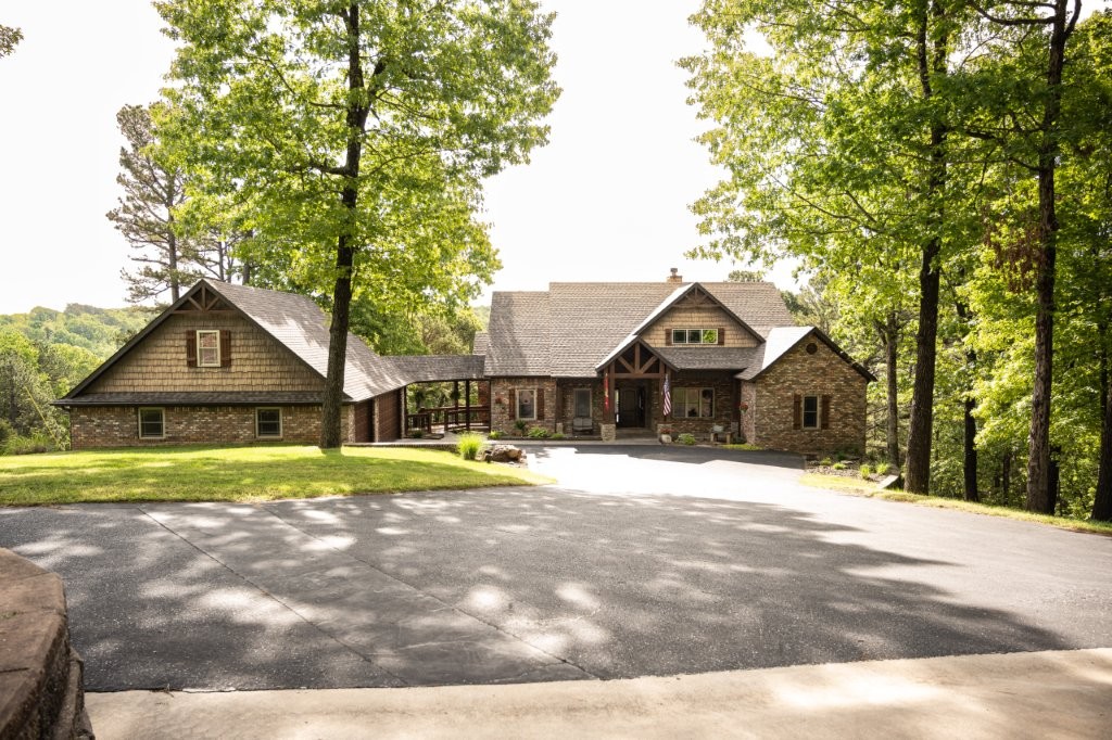 Nestled on 6 wooded acres, this stunning 4,495 sq ft home offers space, comfort, and natural beauty just minutes from Beaver Lake and 15 minutes from Rogers. The main home features four bedrooms and a well-designed layout, while the fully finished basement includes a living area, kitchenette, two bedrooms, and two baths—ideal for guests or multi-generational living. A covered breezeway, inviting drive, and 36x40 shop complete this beautiful home!
