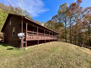Rustic charm meets elegance in this 2100 sf cabin on Pine Twist.  Set atop a hill and surrounded by forest, this home offers beautiful views of Arkansas's natural landscape.  Outside, the recently painted exterior and metal roof blend well with the 11.5 acres of twisting pines and oaks - Perfectly proportioned covered porches on the front and back offer some of the BEST seats in the house for all of Arkansas' four seasons. Ready to go inside? Upon entry, you are greeted with an expansive open floorplan with pine sided walls, towering cathedral ceilings and a rock fireplace with wood stove perfect for our upcoming chilly nights. The split floorplan separates the two bedrooms and hall bath from the main bedroom, large walk-in closet and large main bath with a walk-in shower and a spacious