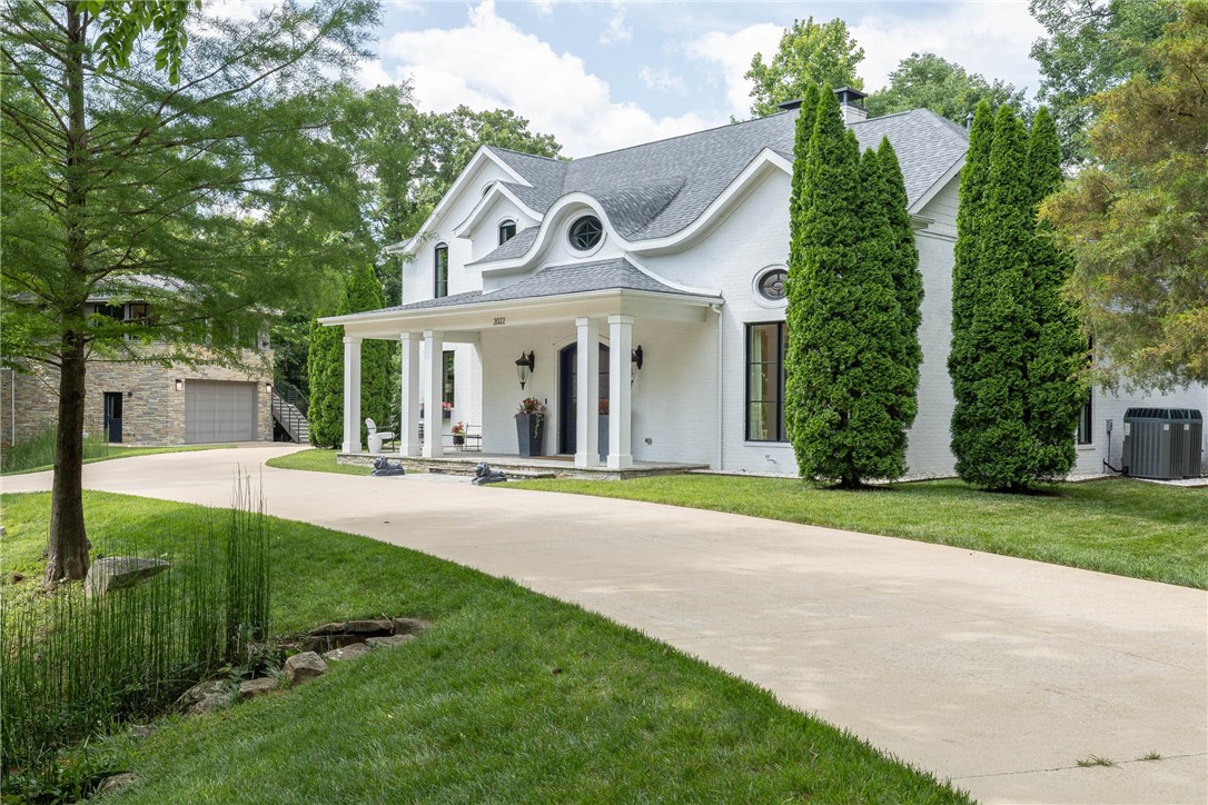 First time on the market! This custom-built Modern European estate just steps from the University of Arkansas blends timeless elegance with contemporary design. Thoughtfully crafted with steel, glass, and concrete for a seamless indoor-outdoor lifestyle. The limewash brick exterior with stacked stone, accented by a stone bridge circular drive, sets a stunning tone. Inside, the main living area is an entertainer’s dream—open concept with a wine bar built from 1871 Chicago fire brick and reclaimed wood. The garage doubles as a luxe flex space with porcelain tile flooring, a ceiling-mounted projector, and a glass door that opens to a spectacular backyard featuring a full outdoor kitchen, built-in seating with custom cushions, concrete entertaining pods, and a hot tub. A detached oversized garage offers boat storage plus a full apartment above—perfect for guests or extended stays. Rare opportunity to own a functional estate in one of Fayetteville’s most desirable locations!