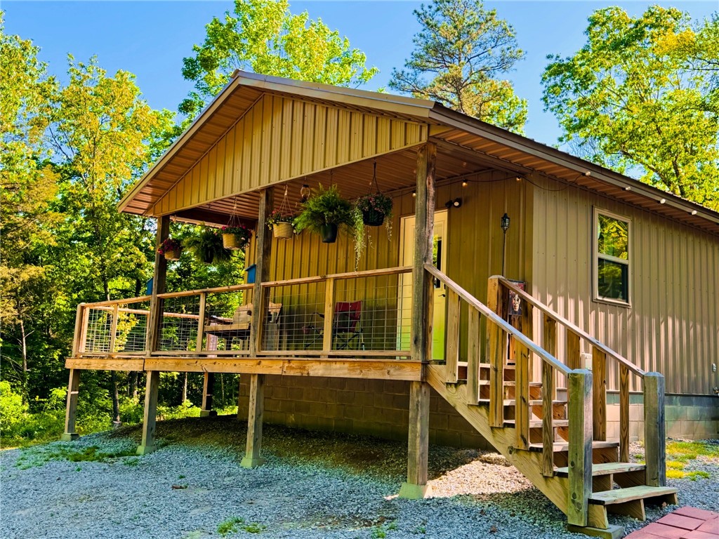Discover 30+ acres of prime Ozark landscape featuring a 1-bedroom, 1-bath cabin with a wraparound porch and inviting country charm. A spring-fed, stocked pond with a scenic waterfall sits just below the cabin, offering a peaceful setting for fishing and relaxation. The property is rich with wildlife, including whitetail deer, black bear, and seasonal elk, making it ideal for hunting or nature enthusiasts. Conveniently located near Wilderness Riders Buffalo Ranch, Outskirts of Heaven RV Park, and Heaven’s Door Cabins, this property offers strong potential as a private retreat or investment opportunity. Just minutes from Boxley Valley and the Buffalo National River.   Elk and bear frequent the property.  Access by deeded easement.  Property currently on shared well with permission to connect to rural water.