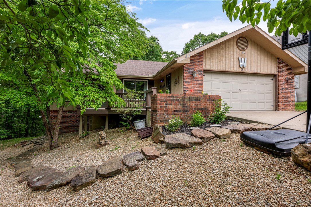 Beautiful home nestled on cul-de-sac, offering peaceful surroundings & scenic views from both front porch & back deck. This home features a desirable open floor plan with an upgraded kitchen and stunning wood flooring throughout the main living areas. Recent updates include a newer roof and water heater, along w/ Pella windows throughout the home for added efficiency and style. The main level includes 2 bedrooms and 2 bathrooms, plus a spacious office/den that can easily be converted into a 4th bedroom. The finished basement provides additional living space, complete w/ separate living area & bedroom—perfect for guests, extended family, or a private retreat. Step outside to enjoy the backyard, where kids can play in their very own treehouse & playscape. Located in the highly sought-after Bentonville School District. Important note: home is on a 2-bedroom septic system. Easy access to scenic trails, lakes, golf courses, swimming pools, & tennis facilities, and miles of scenic trails. A must-see home!