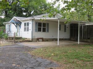Great location--across from the city park! CUTE COTTAGE can be resuscitated with some effort and imagination! Here is your opportunity to restore this 'picture book' residence to a precious home once again! Newer vinyl windows, family room, den, built ins! Spacious floor plan and full of character. EXTRA SHOPS/outbuildings! Cellar in second shop. Sells as is! NO APPLIANCES.