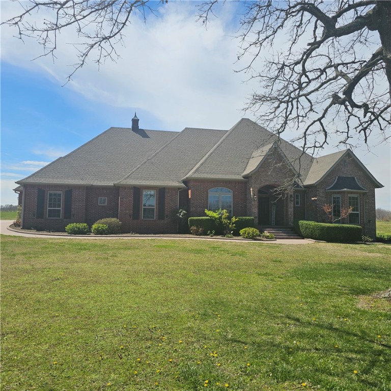 Estate home sitting on 12.18 acres. All open and level except perimeter with wooded acres.  Great for feel of seclusion, yet close to town.  Less than 1/2 mile of gravel road.  Shared pond. 4 or could be 5 BR home.  All on one level except Theatre/Media/Game room upstairs w/ large walk-in closet for storage and/or media equipment.  110” movie screen w/projector, rope lighting and surround sound.  Massive custom trim package w/crown molding & wood window toppers.  One owner custom built home in 2007.  All appliances stay, including Gas propane countertop stove, microwave/convection/conventional oven, ice machine, built in warming drawer/slower cooker, trash compactor, vented hood, dishwasher, smart refrigerator, washer/dryer.  Gas log fireplace & mini-split in enclosed patio with shake shingles on walls & real wood ceiling for lodge like setting.  Upgraded electrical and plumbing fixtures, heated whirlpool tub,2 lg walk-in closets, separate stool area, and sep shower. Oversized 3 car garage & much more. Agent Owned