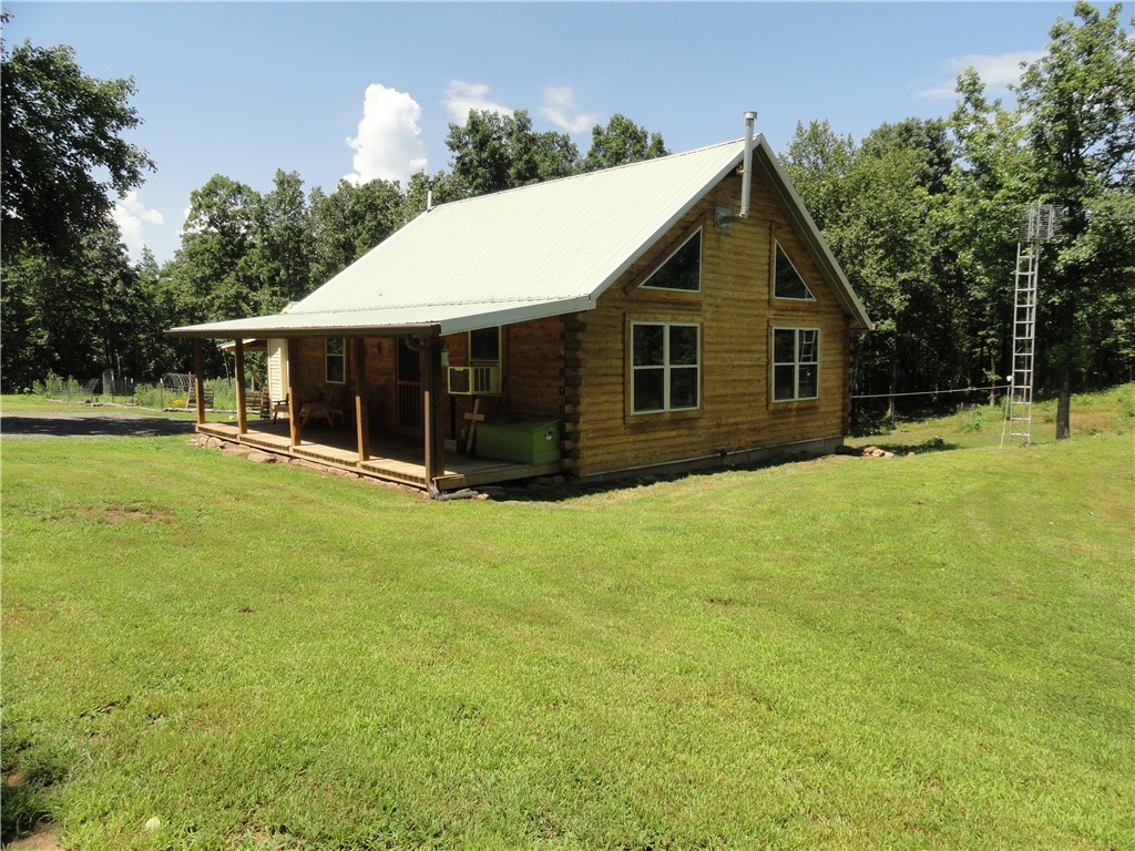 Escape to the heart of the Ozark Mountains with this true log cabin on 20 beautiful acres in north central Arkansas! This charming 1BR/1BA cabin features vaulted ceilings, a wood-burning stove, window A/C, a 12x12 loft, and a covered front porch overlooking the peaceful surroundings. The gently sloping to level land is fully usable, mostly wooded, and offers established walking trails around the perimeter, a small pond, garden area, chicken house, and abundant wildlife for hunters and nature lovers. Property includes highway frontage, a detached one-car garage, and an impressive 40x60 shop with a concrete floor and three oversized garage doors large enough for travel trailers, motorhomes, boats, and more. Conveniently located near major lakes, trout streams, and popular Ozark vacation destinations, this property is ideal for a full-time residence, weekend getaway, hunting retreat, or investment opportunity.