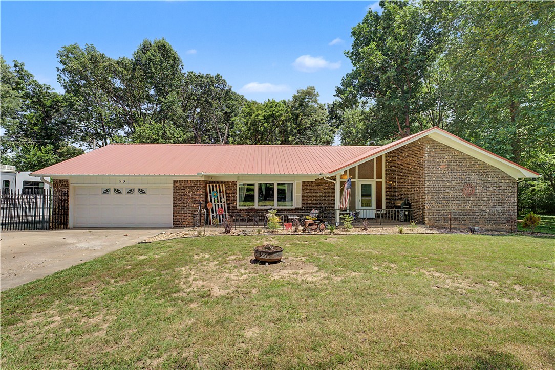 SELLER IS OFFERING $5,000 IN CONCESSIONS TOWARDS CLOSING COSTS OR RATE BUYDOWN (with acceptable offer). Looking for that country feel with large trees and a .85 acre lot but only be about 10 minutes from downtown Rogers?! Look no further! 53 Alton Cir is it! This updated home is in is in a quiet, established neighborhood.  Enjoy peaceful nights in your sunroom in your private backyard among the tall trees.  Or soak in the hot tub in your screened in patio. The kitchen offers considerable counter space and cabinetry and with an eat in kitchen area and a family room with cozy corner fireplace in the open space, it makes it great for family gatherings or entertaining.  Metal roof and iron fencing are low maintenance and easy to maintain. So much to offer with this one!