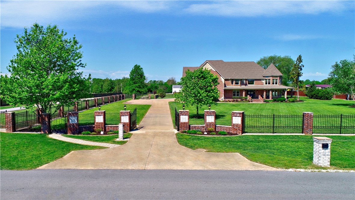 Welcome to your dream mini-farm where luxury meets country living! Situated on 3.19-acre, property is gated & fully fenced. An elegant double door entry w/gas lamps welcomes you inside to 2-story grand entrance w/circling staircase, 4900+ sq. ft boasting 5 full BRS upstairs & a BR/Office conveniently located on the main level. Formal LR & dining room are large w/lots of natural light. The beautifully crafted kitchen has ample seating space open to a family rm & dining area are perfect places for any gathering. The primary suite is on 2nd level is a true retreat, featuring a jetted tub, walk-in shower, 2 separate walk-in closets. There is no shortage of space! Other features: 2 staircases, crown molding, hickory wood floors, & a butler pantry, 609 sq ft pool house w/covered patio, in-ground pool, upscale chicken coop, raised gardens- everything you need for outdoor entertaining & fun. Even more: 4800 sq ft, 4-car garage/workshop w/loft. Minutes from Spr'dale & F'ville, 25 minutes to XNA, Rogers & B'ville. Must see!