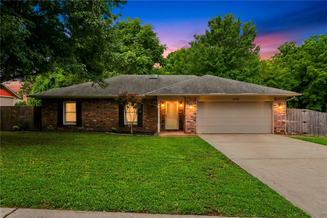 Charming all-brick home tucked into Fayetteville's established Cedarwood neighborhood backing up to the Niokaska Creek Trail and just a short walk to Gulley Park. This single-level 3-bedroom, 2-bath offers an inviting living room with a vaulted ceiling, skylight, and gas-log fireplace, with hardwood and tile flooring throughout. The eat-in kitchen flows to comfortable living space, and the primary bedroom features a walk-in closet. Out back, a covered deck overlooks a wood privacy-fenced yard. Two-car attached garage and a mature, hardwood-shaded lot round it out — all in a prime location near parks, trails, schools, and downtown Fayetteville. Move-in ready.