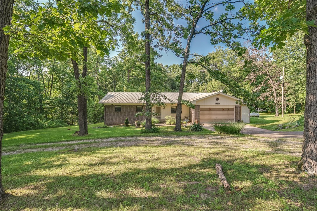 Lovely brick home with lots of potential, in a private setting! Home sits on over 13 beautiful acres, with mature oak and walnut trees throughout property. Nice detached shop building with concrete pad and lean to, for all of your projects. Cozy living room with brick fireplace. Great location with property just approx. 7 minutes away from Centerton.