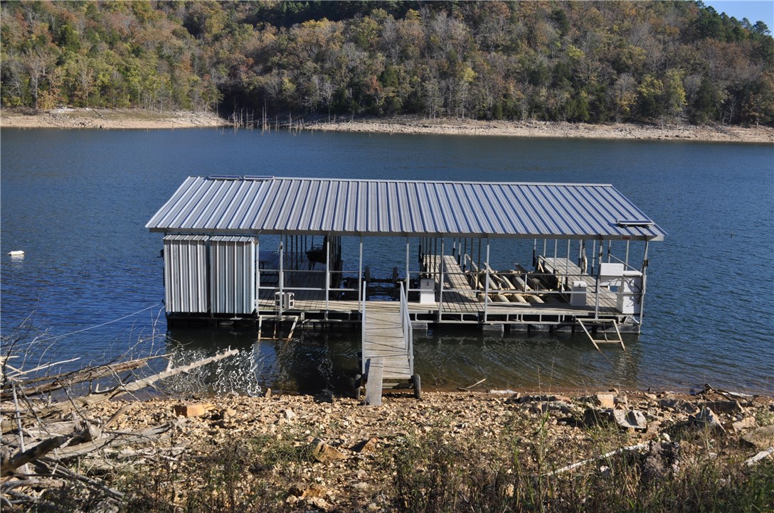 Agent Owned. Cozy well built Lake Front log home. Very secluded with private boat dock. Two slips, two boat lifts and a large swim deck. Nice log home built on a full walk out basement. Back up generator with a 500 gallon propane tank (almost full). Located on one of the best coves of Beaver Lake. Little Cliffty is less busy then most and on the north end of the lake. It is cleaner on the North end. Walk down to the lake about 350 feet. Home has private well. Furnishings, appliances, ATV can convey. High corp line. Private well.