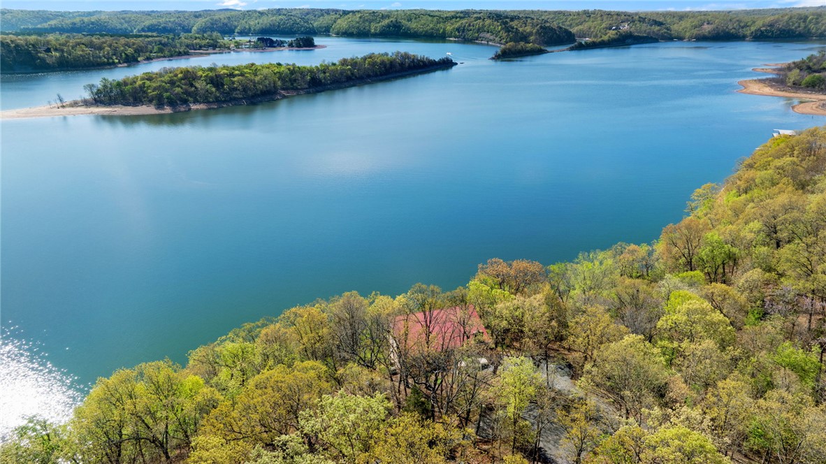 Can you see yourself awakening to the amazing lake view from your bedroom? Enjoy the view while making coffee to sit and enjoy in one of your two all-season lake view sunrooms, taking in the peaceful surrounding nature. Stunning one of a kind year-round view of Beaver Lake - Horseshoe Bend.
Rare opportunity to have 4+ acres; 368 feet of Beaver Lake shoreline right on Horseshoe Bend with a cute cabin/cottage core style home with stairs and a deck to lake.
Plenty of space and sites to build homes for family, Air BNBs, or sell. Endless opportunities and unforgettable views!
Horseshoe Bend Marina is closest boat dock/slip rental; MonteNe is closest boat launch.
Close to town with all paved roads; 10-15 minutes to downtown Rogers; 4 minutes to famous MonteNe Chicken Restaurant. The proximity to NWA features and being "on" the big lake (not a cove) with all-year-round extended, unobstructed lake views is what will make your lake life living perfect. You don't find this combination often. 

Sold "as is"