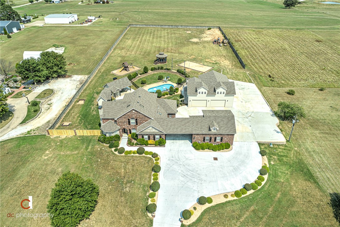 Custom Built home in 2003, recently undated. Designed with Entertainment in mind for all. Inside features include Media room with seating, game room w-wet bar (pool table negotiable), and Exercise room (equipment negotiable). Plus Detached 4 car garage w-large game room/entertainment area w-kitchen space above. Outside features In ground pool, pool house w-indoor kitchen, full bath and outdoor covered gas grill area and plus covered lounge area w-surround sound and flat screen. Plus Gazebo-monkey bar climbing swing play set, Volley Ball court, and Horse Shoe pit. Plus Outdoor Big screen with projector.  This spacious Home truly has it all.  Car collectors will love the 4 car oversized garages plus work shop or 5th car garage with adjacent carport. Nicely Situated on 3.32 level fenced acres.  Potential for Golf or softball practice area, maybe even a basketball court. You decide! Front flower beds have sprinkler heads.