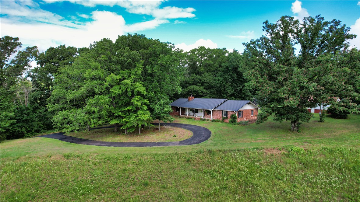 Looking for land with a home? Here is a rare opportunity to own 17.5 acres of private Northwest Arkansas countryside just minutes from all the shopping, dining, and conveniences Rogers has to offer. This one-owner, well-maintained all-brick home features 1,849 sq. ft., 3 bedrooms, 2 baths, office room, large living room, spacious kitchen, and a durable metal roof. A paved driveway leads from Highway 62 to a welcoming circle drive, creating an impressive entrance to the property. The land offers a beautiful blend of open pasture and mature woods, making it ideal for horses, cattle, recreation, hunting, or simply enjoying your own private retreat. A year-round pond adds both beauty and functionality. The 864 sq. ft. metal shop includes a concrete slab, electricity, and finished walls, providing excellent space for projects, equipment, or hobbies. An older hay barn and storage barn add even more versatility. Enjoy the peace and privacy of country living without sacrificing convenience in this unique acreage property.