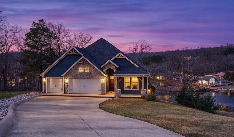 Now offered at $997,000—this Lake Windsor waterfront home with panoramic views and flexible multi-level living is newly positioned to align with today’s buyers. Set on a 0.62-acre lot with ~80 ft of lake frontage, this 3BR, 3BA home offers 3,694 sqft across two levels. The main level features vaulted wood-beamed ceilings, expansive lake-facing windows, and an open-concept great room ideal for entertaining. The primary suite offers lake views, a custom tiled walk-in shower, and a walk-in closet with direct laundry access. A second bedroom and full bath are also on the main level. The walk-out lower level includes a second living area, full kitchen, third bedroom, full bath, and flexible bonus space. Covered outdoor living plus additional lower-level storage for lake gear. Built in 2019 with tile flooring throughout and a 3-car garage. Enjoy lake living with easy access to Bentonville.