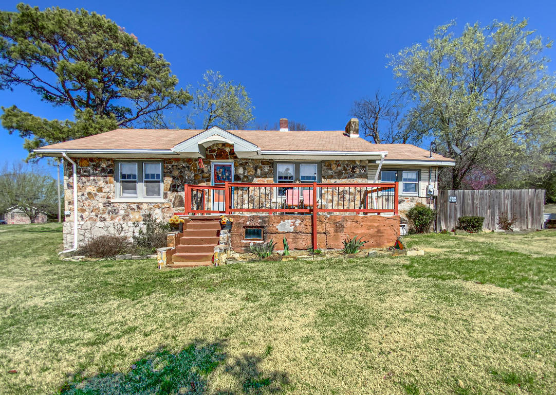 New Roof in the Works!!!  Beautiful historic home in the city limits of Berryville with water and sewer.  Great neighborhood.  Very large lot!!  Conveniently located to all amenities in town. Cozy cottage feel that would make the cutest starter home or aibnb.  The details and craftsmanship are unique.  Original floors. The fireplace in the living room is a great focal point.Fenced in area in the yard for pets.  Home has a sunroom and laundry.  Basement is unfinished. Home and detached garage both have an exterior finish of beautiful Ozark mountain stone. This home is being sold as is.  The price is right.  Come take a look.