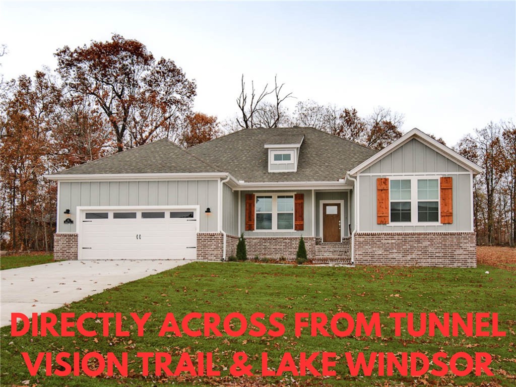 NEW CONSTRUCTION LOCATED DIRECTLY ACROSS THE STREET FROM THE TUNNEL VISION TRAIL & LAKE WINDSOR! LEVEL .32 ACRE LOT!  Quick access to Bentonville. Features include a split floor plan, gas fireplace, LVP throughout, vaulted ceiling w/ beams, 3 cm counters, custom cabinets w/ wood hood, gas range, pantry, oversized eat-in kitchen, and high-end finishes throughout! Primary bath includes a large walk-in tile shower, free-standing soaking tub, double vanity, and generous closet space! Spacious covered patio area in both the front and back is ideal for entertaining! Approx completion date is 7/31/25 **Pictures may not be of exact unit listed, colors may vary slightly.