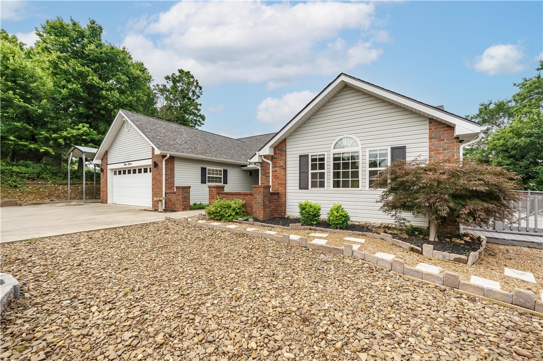 Perched on 2.4± mountaintop acres, this beautifully updated 3-bedroom, 2-bath home offers remarkable views from both the front and back—including Table Rock Lake, Beaver Bridge and Smith Castle. Step inside to find new paint, flooring, lighting and ceiling fans, along with a kitchen featuring all-new appliances, Corian countertops, abundant cabinetry and a generous gathering bar. The spacious primary suite includes a jetted tub, walk-in shower and ample storage, while the bright all-seasons sunroom provides the perfect place to relax and take in the natural surroundings. Outside, a 936 sq. ft. insulated metal shop/garage with mini-split offers comfortable year-round workspace, storage or room for hobbies, plus an attached RV carport. With the roof and HVAC less than three years old—and Table Rock Lake and the marina just minutes away—this mountaintop retreat combines sweeping scenery, thoughtful updates and exceptional versatility.