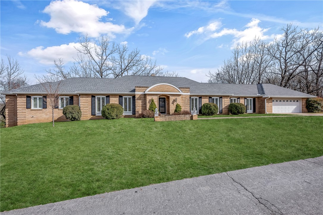 Custom-built in 1965 & known as the Puckett House, this iconic Siloam Springs home has had only three owners.  Perched atop a hill within walking distance to downtown & JBU, the views from the back terrace are breathtaking- overlooking a creek & beautifully landscaped, wooded grounds.  Quality construction includes steel beams, French drains, and a library designed as a storm shelter with air shaft access.  Original countertops in all bathrooms include marble, travertine, and tile, floating wall mounted toilets, original chandeliers, crown molding, and detailed millwork reflect timeless craftsmanship.  Pella windows with roll-out screens, heated and cooled storage, lower-level would work great for multigenerational families, plus new roof, gutters, skylights, carpet, front door, Iron fencing on the terrace, Pella windows in the front replaced and more.. Full list of updates, survey, and building plans available.  Meticulously maintained- homes like this are rarely built today.