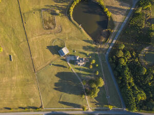 Nestled amidst serene mountains, this exquisite 3,200 sf home graces 15.2 acres of pristine pastureland. Its expansive grounds feature a bountiful pond teeming with fish & a fully-equipped barn tailored for equestrian enthusiasts, complete with a tack room, shower stall, and corral & dual covered RV parking. Step inside to experience luxury & comfort. A grand formal dining room, a state-of-the-art kitchen showcasing a 36''gas range,& a master suite with a lavish soaker tub, expansive closet, and dedicated office space. Two spacious rooms on the ground floor cater to family needs, while the upper level unveils a versatile bonus room accompanied by two additional bedrooms & a bonus room.The home has a brand new roof & the dishwasher and hot water heater have been replaced in recent years.