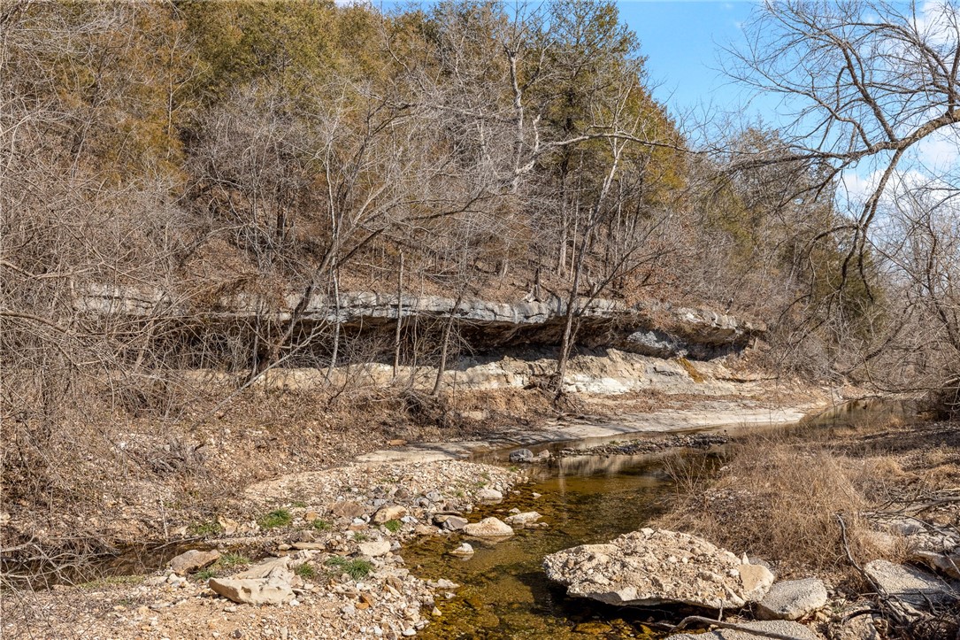 Piece of Ozarks paradise!!  This 55.50 +/- acre property is flexing with so many wonderful features; year round running creek, Marble Fork Creek, a Spring, private driveway with arch entrance in place, small cave, hunting opportunities till your heart is content, gorgeous boulders, bluff lines, outcropping rock formations and it's located only 10 minutes to Harrison! Electric is on site.  The Spring is the current water source.  Septic is needed.  If you've wanted a piece of property to build your dream home on, a vacation home, hunting cabin or a piece of land to have for recreation - I'm not sure it gets better than this.  Loaded with morel mushrooms, wildlife, large timber and year round running water, this 55.50 +/- acre tract is sure to please.  Bonus one: there is a swimming hole just down the road under the train trestle bridge...very cool!  Bonus two:  the Airstream on the property will come with the land should the buyer desire to have it. Come see for yourself!  Buyer to verify utilities.