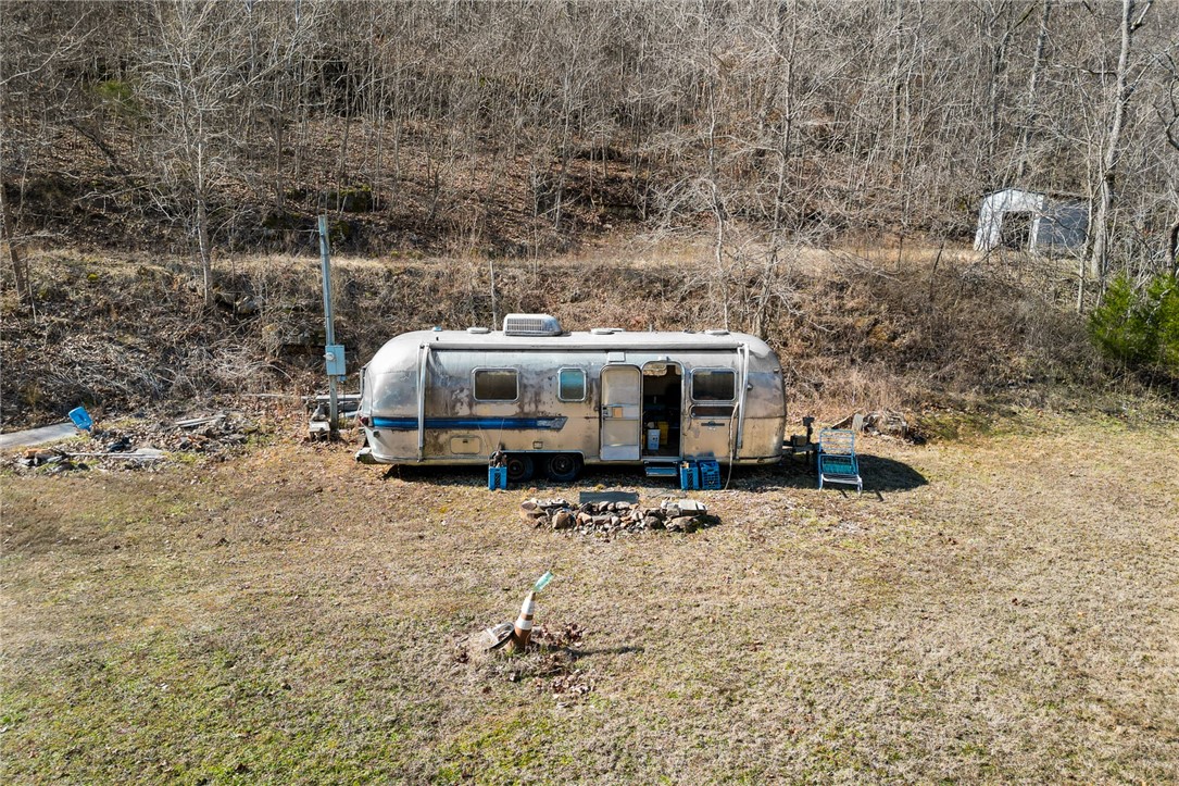 Piece of Ozarks paradise!!  This 55.50 +/- acre property is flexing with so many wonderful features; year round running creek, Marble Fork Creek, a Spring, private driveway with arch entrance in place, small cave, hunting opportunities till your heart is content, gorgeous boulders, bluff lines, outcropping rock formations and it's located only 10 minutes to Harrison! Electric is on site.  The Spring is the current water source.  Septic is needed.  If you've wanted a piece of property to build your dream home on, a vacation home, hunting cabin or a piece of land to have for recreation - I'm not sure it gets better than this.  Loaded with morel mushrooms, wildlife, large timber and year round running water, this 55.50 +/- acre tract is sure to please.  Bonus one: there is a swimming hole just down the road under the train trestle bridge...very cool!  Bonus two:  the Airstream on the property will come with the land should the buyer desire to have it. Come see for yourself!  Buyer to verify utilities.