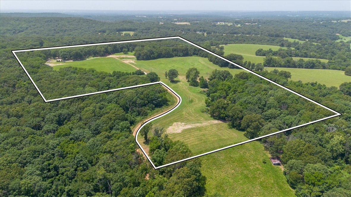 Way more than just a piece of land! Must see 45.42 secluded acres surrounded by trees and an abundance of wildlife that touches the Pea Ridge National Military Park. There is a quaint tiny home/cabin on the property with all the amenities needed. Perfect to stay in while hunting or building your dream home. Already on site are 2 wells and electric with 400 amps on the property already along with foundation walls.  No restrictions.