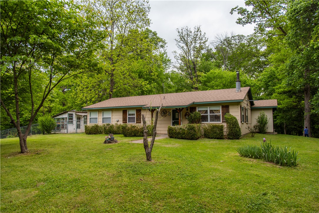 This lovely 3/2 home with 1695 SF rests on 1.07 acres. This home, while on Hwy 43, sits back in the property, offering plenty of privacy. Sit on the covered back deck with your morning coffee and listen to the birds chirp while you read the morning news. Store all of your outdoor toys in the 20x20 shop out back complete with shelving for all of your tools. The backyard is fenced for your 4-legged friends. Inside, the kitchen is loaded with cabinet space for the chef of the house! The island is just waiting to be used for baking cookies! The bedrooms have ample closet space. The primary suite offers a separate tub and shower. Cool nights can be spent next to the wood burning fireplace. There is a small basement for you just off of one of the bedrooms. This property has so much to offer your family; nice home, expansive shop, beautiful secluded acreage and desirable location. You are 2.5 miles to Allen Elementary or JBU and 3 miles to downtown Siloam Springs. Don't miss this property! Schedule your showing now!