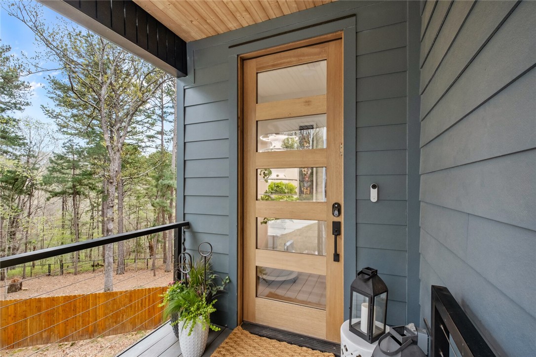 Modern comfort meets natural beauty in this 2022-built gem on a 0.5+/- acre sewered lot near the Back 40 trails. This 3BR/3BA + office which could be 4th bedroom with door, window, & adjacent storage.  The home features floor-to-ceiling windows that flood the main level with light. The open living area boasts a two-sided gas log fireplace shared with the back balcony. A chef’s dream kitchen offers Frigidaire Gallery appliances, quartz countertops, and sliding glass doors leading to a covered composite deck—perfect for tranquil entertaining. The upper-level primary suite includes a walk-in closet and en-suite with a tile shower and double vanity, while a second guest BR has easy hall bath access. The first level provides practical luxury with a garage, storage lockers, built-in desk, and an office. Need more space? Outside, a Metal Cowboy pool conveys for the ultimate summer retreat in a wood privacy & chain link fenced back yard! This home perfectly blends sleek design with world-class trail access.