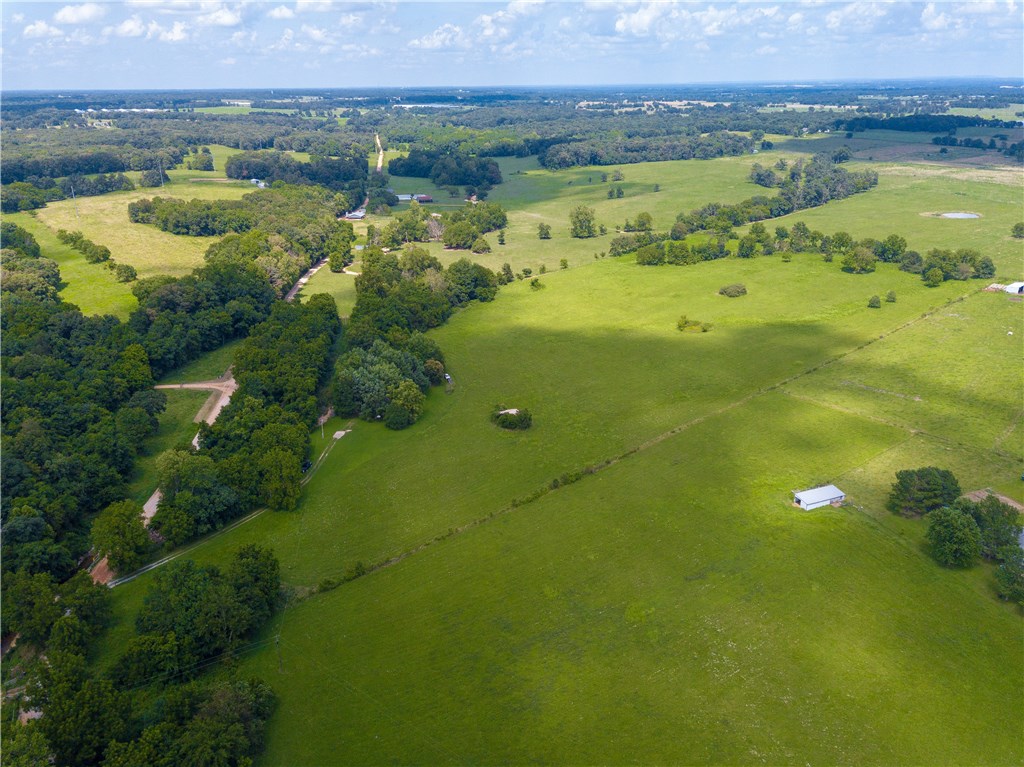 Gorgeous land with limitless possibilities! Live in the mobile while building your dream home on your choice of several incredible home sites on this spectacular acreage. Over 24 acres of rolling pasture & mature trees with beautiful views. Live creek running through by west border of property, outbuilding. Great country location yet just minutes away from XNA.