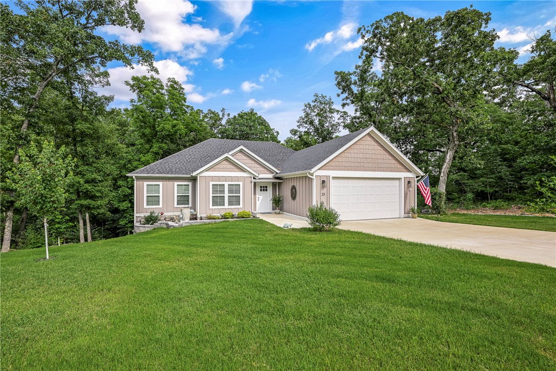 Nestled among the tree canopy of Bella Vista, this 4 bedroom home offers the perfect blend of natural beauty, thoughtful design, and extensive upgrades that make it truly better than new! Conveniently located near mountain bike trails, golf courses, & lakes. The flat driveway is the first perk, while the garage has been enhanced with a durable epoxy-coated floor and custom built-in storage solutions. Professionally landscaped on all sides, the property showcases attractive plantings, carefully designed retaining walls that terrace the natural slope, and raised garden beds. Outdoor living is elevated with a 10 x 16  extension of the original builder's deck & a dedicated gravel firepit area. Notable additions inside: custom blinds, all windows are cased in wood, designer feature wall in entry, stone fireplace surround, large kitchen pantry, his and her closets in Primary suite & beautiful tile work in the shower. Consider all the benefits of a "nearly new" home and see this home today!