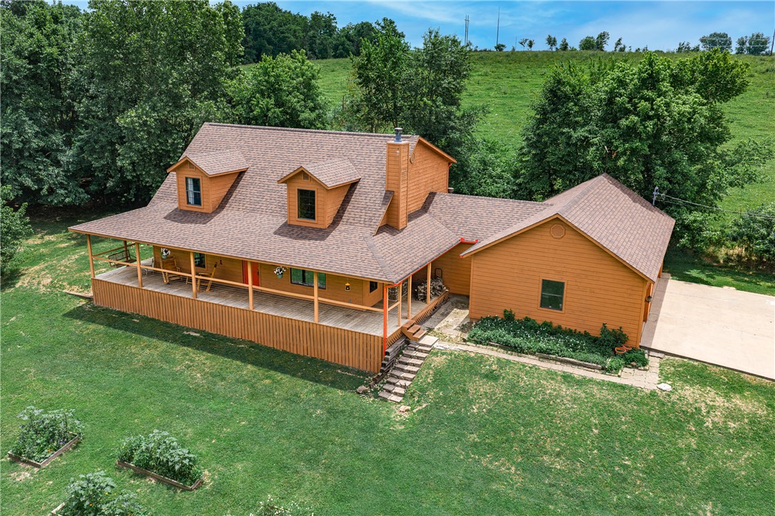 Tucked in the heart of NWA yet worlds away, this country-style retreat is a rare find that checks every box. The en-suite primary bedroom offers a quiet sanctuary, while four bedrooms and three baths across 2,258 square feet give everyone room to spread out. A large wrap-around porch frames breathtaking sunset views — the perfect end to any day.
The grounds are a hobby farmer's dream: fully fenced and cross-fenced with zero covenants, a massive metal shop for every project, and a 3-car garage complete with a large tornado shelter. Explore your own year-round cave spring-fed creek, soak in the color of vibrant Redbud trees, and enjoy rare deeded access to state-owned land to the west.
The kids will claim the heated and cooled treehouse as their year-round kingdom — or reclaim it as your she-shed. Raised garden beds round out this one-of-a-kind property that delivers true country living without sacrificing a central NWA location.