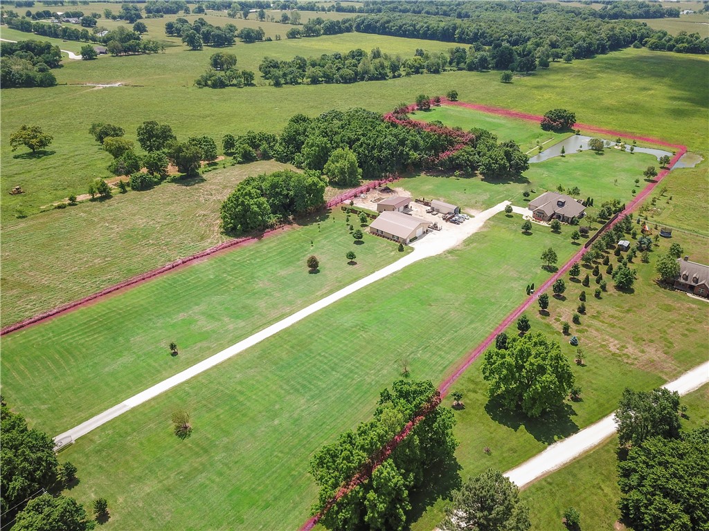 Now is your chance to own this one of a kind estate located on 12.93 acres of peaceful land in Prairie Grove. The home is conveniently located between Farmington and Prairie Grove so you can decide what school the kids will attend. The pictures simply don't do this home justice. With this home, there are endless possibilities for creating memories with loved ones and friends! Come enjoy the sounds of the outdoors, read a book by the sparkling pool, ride horses, or simply drink a glass of wine and watch the gorgeous sunsets from your cozy back porch! This home features 3 Bedrooms, 2.5 Baths, plus two additional rooms that could be utilized as bedrooms!  Majestic master-suite, walk-in closets, built-ins, amazing views, heated pool.  This home also boasts an indoor half basketball court and gym in the massive outbuilding, plus a fully stocked pond, and so much more.