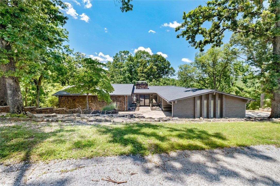 Cool Vibes in this LAKEFRONT Mid-Century Modern Lake Home w Lakeviews & New 2-SLIP Private Dock w Swim Platform, all Very Close to Town! Perfect Entertainment Oasis thru-out boasting Vaulted, Beamed Ceilings in the Sunken Family Room w Gorgeous Rock Fireplace & Sliding Doors to NEW Upper Deck. Den is Open to the Oversized Dining Room & Chef’s Kitchen w Wrap-around Island & Tons of Barstool Seating, as well as Eating Area with Bar. 4 BR, 3BA and Huge Walk-out Basement offering 2nd Living Room & Stone Fireplace, Pool Table and Ping Pong Table w Sliding Glass Doors Access to Lower Level Patio. One of the Bedrooms & Bathroom located downstairs, as well as a large Laundry/Mud Room. Tons of Storage under house as well. Enjoy Game night or Serene Nature in backyard as well as Lighted Pathway down to the Private Dock in Secluded Cove. Great Airbnb or Entertainment Retreat!