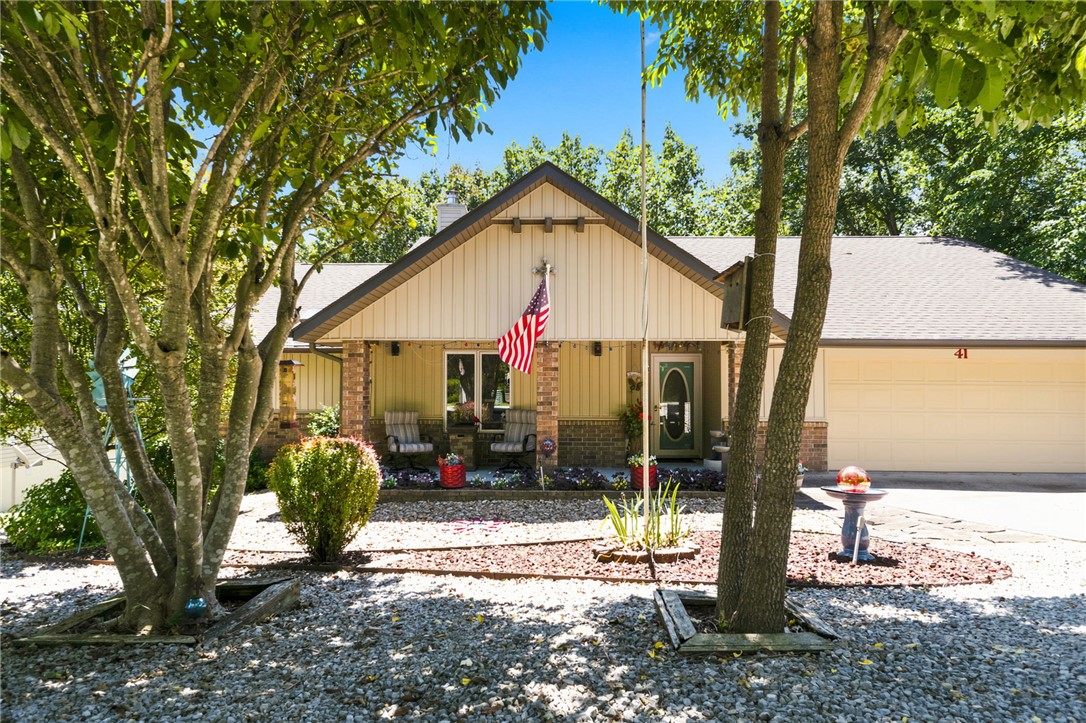 NOW OFFERED AT $424,500! Move-in-ready home with an adjacent BUILDABLE LOT creating a rare .55-acre opportunity just minutes from Lake Windsor. The additional lot is perc-tested with a septic design plan, providing exceptional privacy plus future potential for a detached garage, workshop, RV parking, or other improvements. Inside, enjoy fresh paint, updated kitchen and baths, newer roof and HVAC, Pella windows, and luxury vinyl plank flooring throughout. The flexible single-level floor plan offers 3 bedrooms, multiple living areas, and a split-bedroom layout ideal for guests, hobbies, or a home office. A vaulted living room with skylight and fireplace opens to a bright four-season sunroom overlooking a peaceful wooded setting. Garage features built-ins and utility sink; lower-level 15x15 storage/workshop. Private deck, hot tub that conveys, and easy access to Lake Windsor, OZ Bike Park, trails, and Bella Vista amenities.