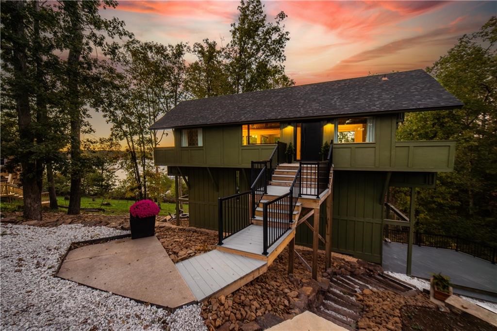 Perched among the trees with stunning Beaver Lake views, this storybook lakefront home offers a blend of architectural charm and outdoor adventure. Extensively remodeled in 2023 down to the studs, this mid-century modern lake house showcases clean lines, an open layout, and expansive windows that frame the natural surroundings. Set on a private road leading gently to the community dock, the property includes two private boat slips—one covered with a solar-powered lift and one uncovered, ideal for a sailboat. Every detail has been thoughtfully updated, including energy-efficient windows, new HVAC, appliances, and finishes. A personal sauna and seamless indoor-outdoor flow create the perfect space to unwind after a day on the lake or nearby trails. With an unbeatable location to Downtown Rogers, Prairie Creek Marina, Hobbs State Park, and Bentonville, this is a one-of-a-kind retreat where mid-century design meets lakefront treehouse.