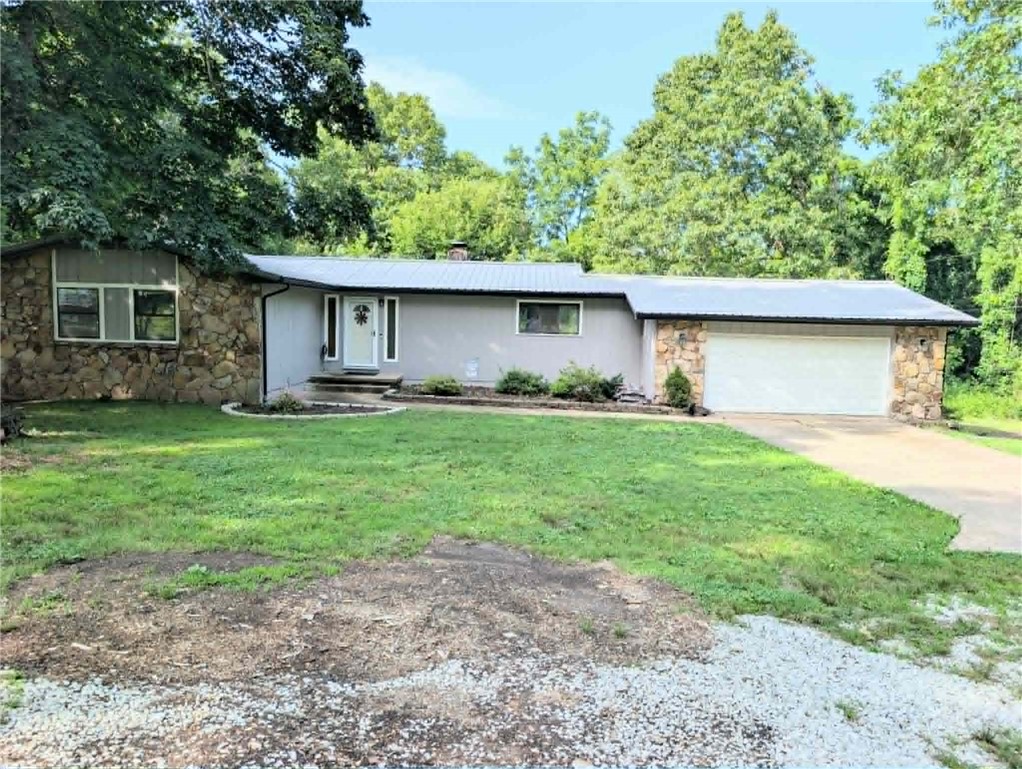 Welcome to your private retreat, nestled on 5 partially fenced acres and tucked behind mature trees. This beautiful 4-bedroom, 3-bath home offers the privacy you've been searching for while remaining just minutes from Harrison.
With approximately 1,550 square feet on the main level and an additional 650 finished and 450 unfinished in the basement, there's plenty of room for family, guests, hobbies, and entertaining. The layout features two inviting living areas, each warmed by its own stone fireplace, creating cozy gathering spaces for every season. The large kitchen features quartz countertops and ample space to prepare meals & host family gatherings. The adjoining living and dining areas flow seamlessly, making entertaining effortless. Downstairs, the second living space provides incredible flexibility and room to thrive. The 25x30 shop with water and electric access nearby is ideal for projects, equipment storage, livestock needs, or running a hobby farm. This gem is one you won't want to miss.