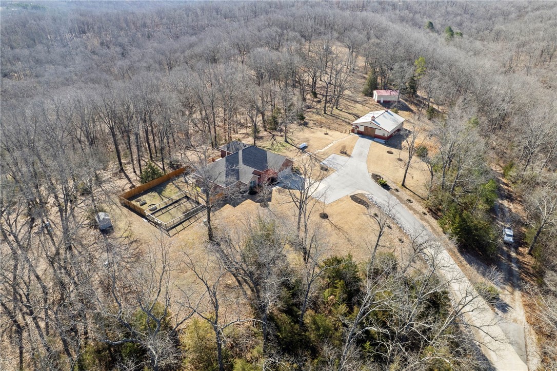 Want an escape from the city within 10 minutes of downtown Rogers? Looking for a location within minutes to Beaver Lake marinas and boat launches? Would you like a possible revenue stream or extra space for visitors? Have farm animals that will need their own space? Need a workshop or a place to store your boat and ATVs?  This property has all that on 25.83 acres. This custom home was built to be energy efficient without skimping on the finer details. Schedule your viewing near dusk and you may catch the breathtaking sunsets over the tree tops.