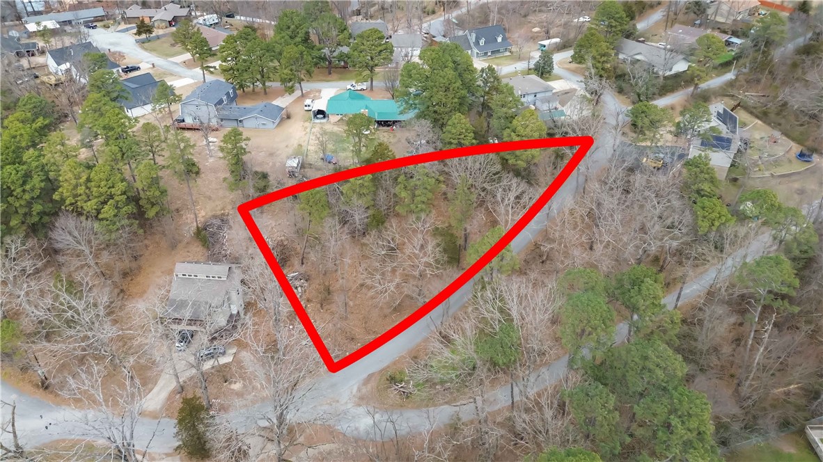 Wooded residential lot located in Pine Ridge Estates, offering approximately 0.29 acres of natural surroundings in Rogers. The sloping, south-facing property provides a peaceful setting with mature trees and potential for a private homesite. Utilities including public water and electric are available at the street. Conveniently situated near Highway 12 with easy access to Rogers and the surrounding Northwest Arkansas area. A great opportunity to build in a quiet neighborhood setting while still being within a short drive of local amenities and outdoor recreation.