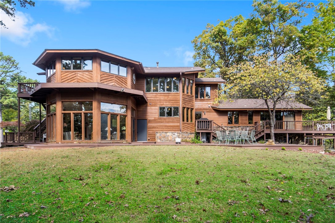 5 Beautiful acres so very close to Downtown Rogers on a very private estate.  The Sellers are the original owners who designed and personally built this highly crafted custom home - completed in 1988.  This home design is inspired by the very best architects of our era. A labor of love in every nuance. The setting offers stunning natural beauty on all sides.  A gentle walk to your "hard-to-find" enclosed private boat dock with boat lift and swim deck. The home itself has many special places for reflection and to enjoy nature. Designed with separate quarters or "wing" for extended family or visitors.  Features include a scenic sunroom/living room combo, three fireplace's, spacious rooms with walk in closets, Quartz counters with cultured marble in the downstairs vanity.  Propane powered "All-House" generator for complete peace of mind. Pleasant Ridge is truly a dwelling place where dreams call home.