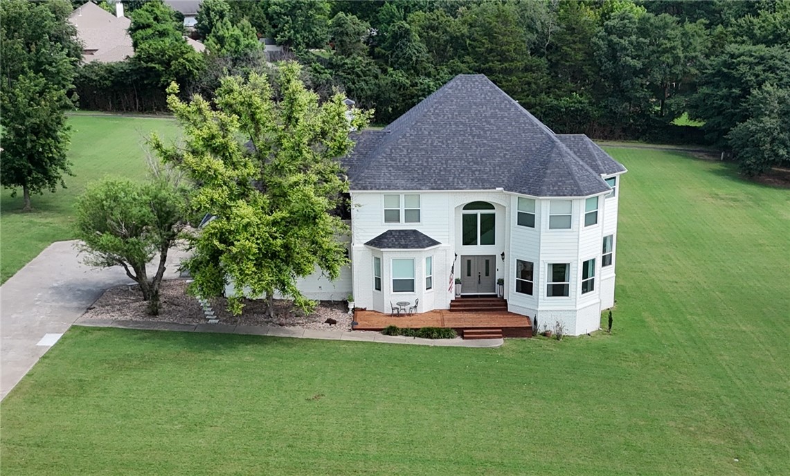 Welcome home to this beautiful property in Ridgemonte View, offering stunning Boston Mountain views and an unbeatable combination of comfort and convenience. Set on a spacious, open lot, this home invites kids to play, pets to roam, and families to gather. Once inside, you'll find an impressive entryway with hardwood floors and large windows in every direction. The first floor also features an office with double doors, full bath, large laundry, and a wood-burning fireplace in the living room. Major updates include a new roof, gutters, exterior siding, cedar deck, front doors, and paint all within the last five years. The upstairs bedrooms capitalize on the views in every direction and a giant bonus space could serve any purpose well! Located in a highly desirable area only a mile from Mission and Crossover with excellent schools, the neighborhood also features a one-mile walking path around the perimeter, ideal for family strolls or jogs. Convenience, space and views... This is what you've been waiting for!