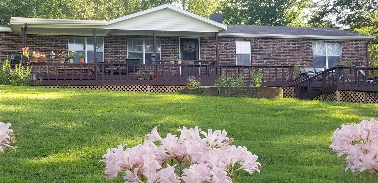 Beautifully updated, private, peaceful home on 4 acres. Great for home business, horses, gardening or city getaway. Home features huge sunroom, tongue-groove pine ceiling great room with large wall to wall brick wood burn fireplace, 2 living areas, 1 w/parquet wood, perfect for dancing! 4 beds or 3 beds/office. Fenced area w/arbor for entertaining. Formal dining & large laundry area. Newer roof, newer X-large 2 car garage. Well maintained home. Sunroom is 480 square feet.
