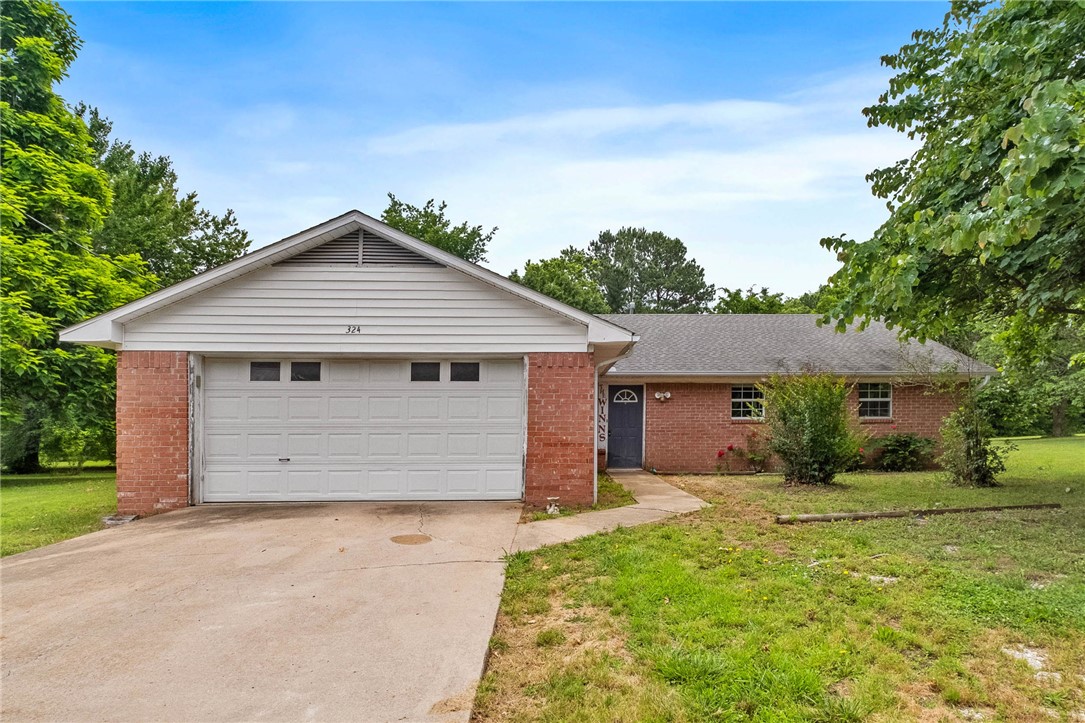 Flat 1.61-acre property in a quiet cul-de-sac type setting with Fayetteville address located in Greenland. Less than 2 miles to I-49 with convenient access to the University of Arkansas, Drake Field Airport, and major Northwest Arkansas employers including the Bentonville home offices. Established 3BR/2.5BA home offering wheelchair/handicap accessibility in the half bath, large primary suite with 2 closets, spacious bath, and additional long closet. Features include a woodburning insert, 2-car garage, mature pear trees, and beautiful usable land with endless potential. Previously a pristine garden, the rich soil is ideal for planting again with mature blackberry and raspberry bushes already established. Home needs updating and some repairs but offers an excellent opportunity to customize, renovate, or invest in a hard-to-find level acreage setting that feels peacefully tucked away from town while still being less than 2 miles to I-49 and under 15 minutes to the University of Arkansas.