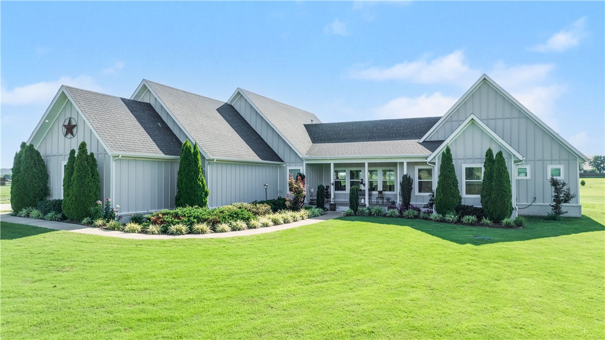 Set on 2.05 acres in Prairie Grove, this beautiful Craftsman-style home offers a thoughtful split floor plan with an open-concept heart. The primary suite and a bedroom/office sit privately on one side of the home, while three additional bedrooms are situated on the opposite side — two connected by a Jack-and-Jill bath, plus a third en-suite bedroom offering flexibility for guests or a mother-in-law setup — with the open kitchen and living area anchoring the space in between. The living area is warmed by a fireplace and filled with natural light, taking full advantage of sweeping pastoral views throughout. The chef's kitchen features butcher block and quartz countertops, a Thor six-burner double-oven convection propane range with griddle, and an eat-in breakfast nook. Additional upgrades include a hot water circulating system and a three-car garage with a 220V outlet. Pet-friendly home, odor-free. Out back, patio has been extended as well as buried propane line to off availability for tankless propane grill.