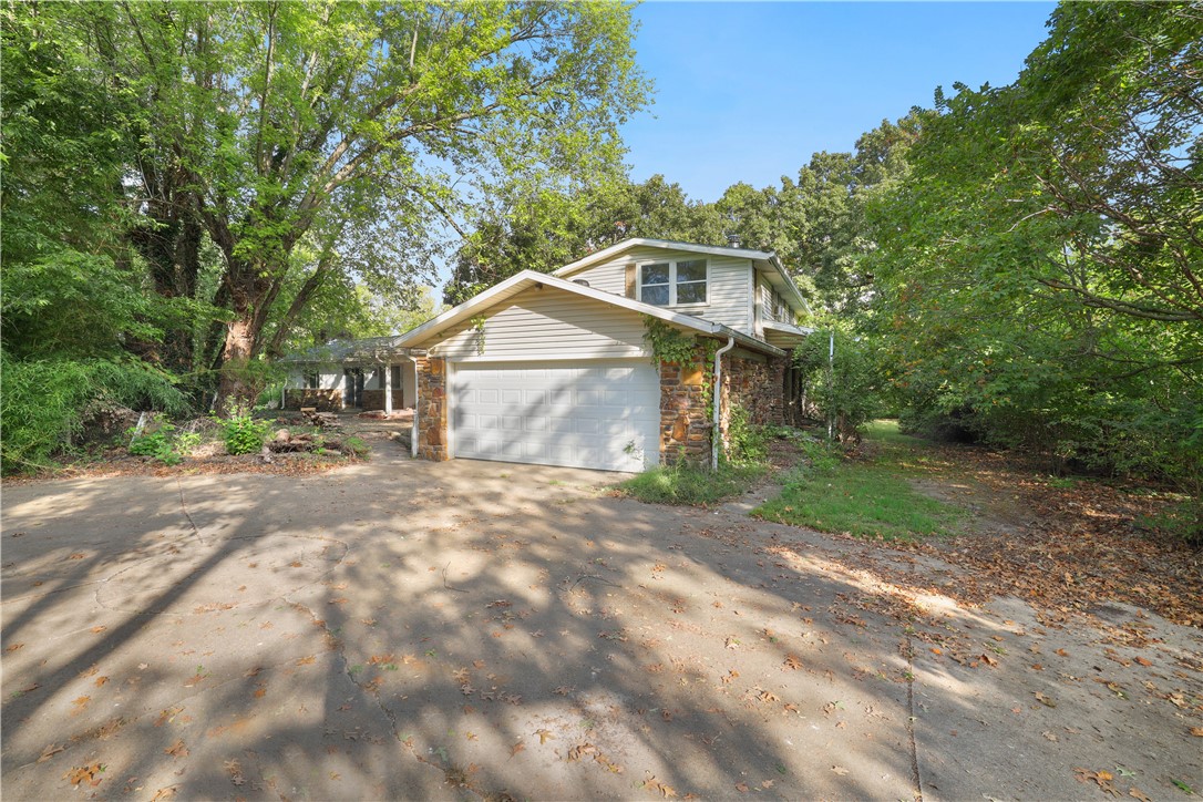 The possibilities are endless with this family home and 18.88 acres. The home sits in on a beautiful flat lot with porches on three sides. With TLC this home could have many more years of memories. The property has an additional detached garage, a barn, a pond started and several fenced areas. Further back into the property is heavily wooded and rolling. Mini Farm, sure! Hunting haven, sure! Just minutes from Lake Wedington in one direction and restaurants and shopping in the other direction.