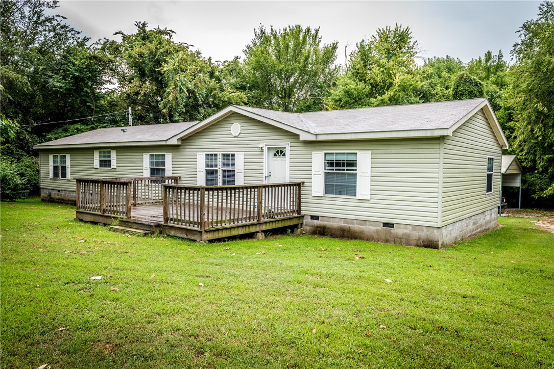 Country feel not far from town! Gorgeous 2.01 acres featuring 4BD/2BA on permanent foundation, large front deck, 2 spacious LRooms, open floor plan, large eat-in kitchen w/ wood laminate throughout, abundant cabinetry, center island, backsplash & trendy lighting, Large MBedroom, MBath featuring His&Her sinks, walk-in shower & tub, additional large bedrooms, sink in utility, back deck access through living room, kitchen view, 20x20 carport, 12x20 & 8x12 storage building.