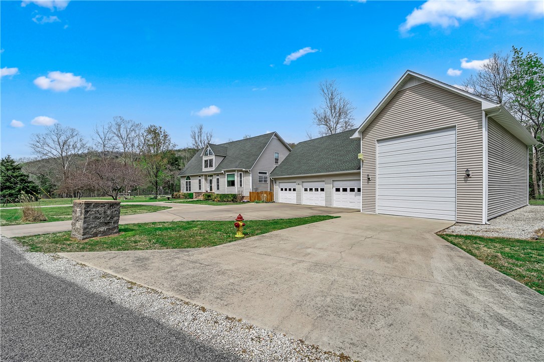 Tired of NWA traffic? Want to commute to Rogers and Bentonville but come home to a peaceful paradise? Welcome to Holiday Island — America's Best Kept Secret — and the word is getting out! This stunning, private 3-bed, 2.2-bath colonial sits on .82 acres with breathtaking Ozark Mountain views and unmatched peace and privacy. Minutes from the coveted Holiday Island Marina, enjoy free and easy boat access to Table Rock Lake — a legendary fisherman's paradise famous for world-class fishing. Perfect for water lovers! Inside, 2,305 sq ft features soaring ceilings up to 29 feet, granite counters, a jetted tub, and walk-in closets in every bedroom. Major updates include a 2023 roof, new AC (2025), triple-pane windows, and a whole-home generator. A massive RV garage, 3-car garage, and attic storage are unmatched. The included second lot is flat and buildable. Community pool, golf, tennis, and trails complete this rare gem.