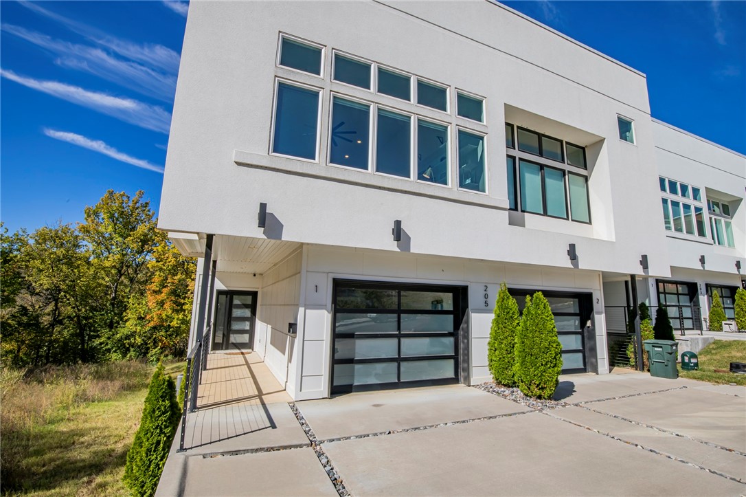 The location doesn't get much better being across the street from the Fayetteville Public Library, just 5 blocks from the Fayetteville Square AND the Walton Arts Center.  This incredible downtown home sits just off the Frisco Trail portion of the Razorback Greenway, giving you the option to walk or bike to just about anything on UofA campus, Dickson St. or the Square. This modern luxury home has the feel of an urban loft with high-end finishes throughout.  Split-level entry featuring floating steps catches your attention as you enter. The main living area features a custom bar with wine refrigerator, a fantastic modern fireplace, and high ceilings with massive windows overlooking the new library addition.  The kitchen features custom cabinets, quartz countertops, and an overhead door that opens to the rooftop deck.  The primary suite has views of the Trail and a custom glass shower between the bed and bath. HUGE rooftop garden patio for entertaining! Two beds downstairs with a laundry room and second full bath.