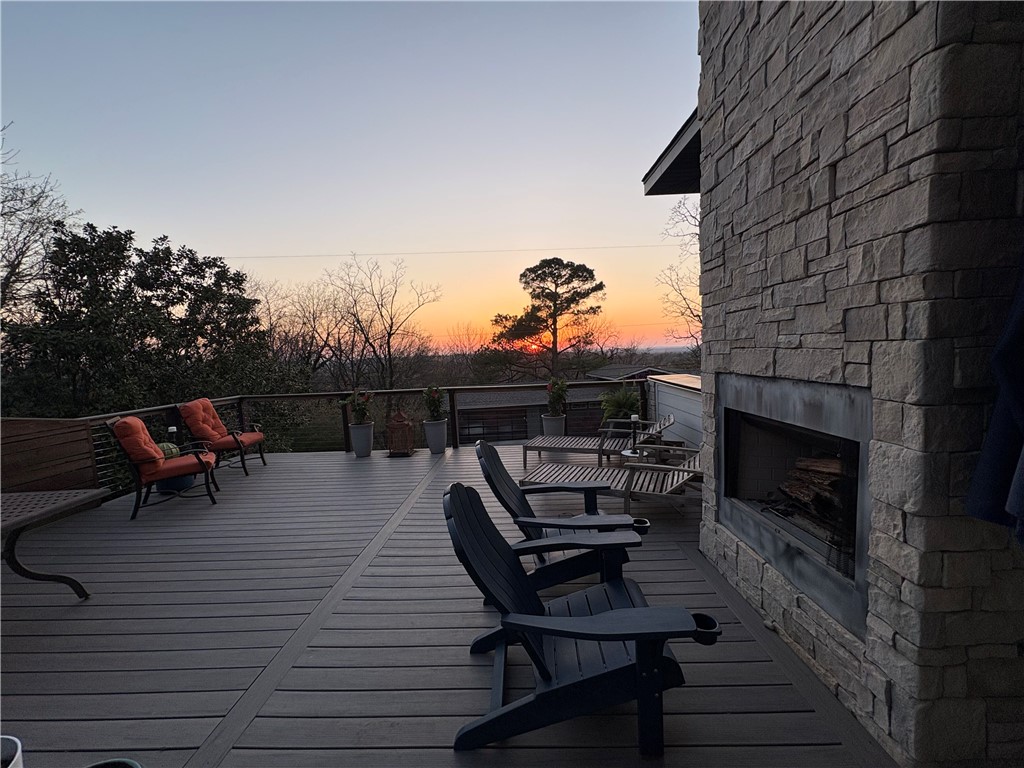 Gorgeous, breathtaking views greet you daily from the 500 SF rooftop deck, complete with wood-burning fireplace and sweeping sunset views across Fayetteville. Home was taken back to the studs for a full remodel in 2021 with all new major systems: electrical, plumbing, insulation, multi-zone HVAC and 100-gallon water heater delivering on-demand hot water. The living area centers around a fireplace with natural light pouring through a wall of windows. Reimagined kitchen, designed within the home’s original footprint, is ideal for any cook. Custom-built nook, perfect for pets or kids, showcases repurposed original flooring as a unique architectural accent. Main level features private primary wing with two walk-in closets, dual vanities, integrated laundry and tiled walk-in shower. 2nd bedroom/office and a full bath complete level. Upstairs, a light-filled landing with kitchenette connects two bedrooms and full bath with original 1935 cast-iron tub and bonus flex space. Rare 2 car garage and big functional fenced yard.